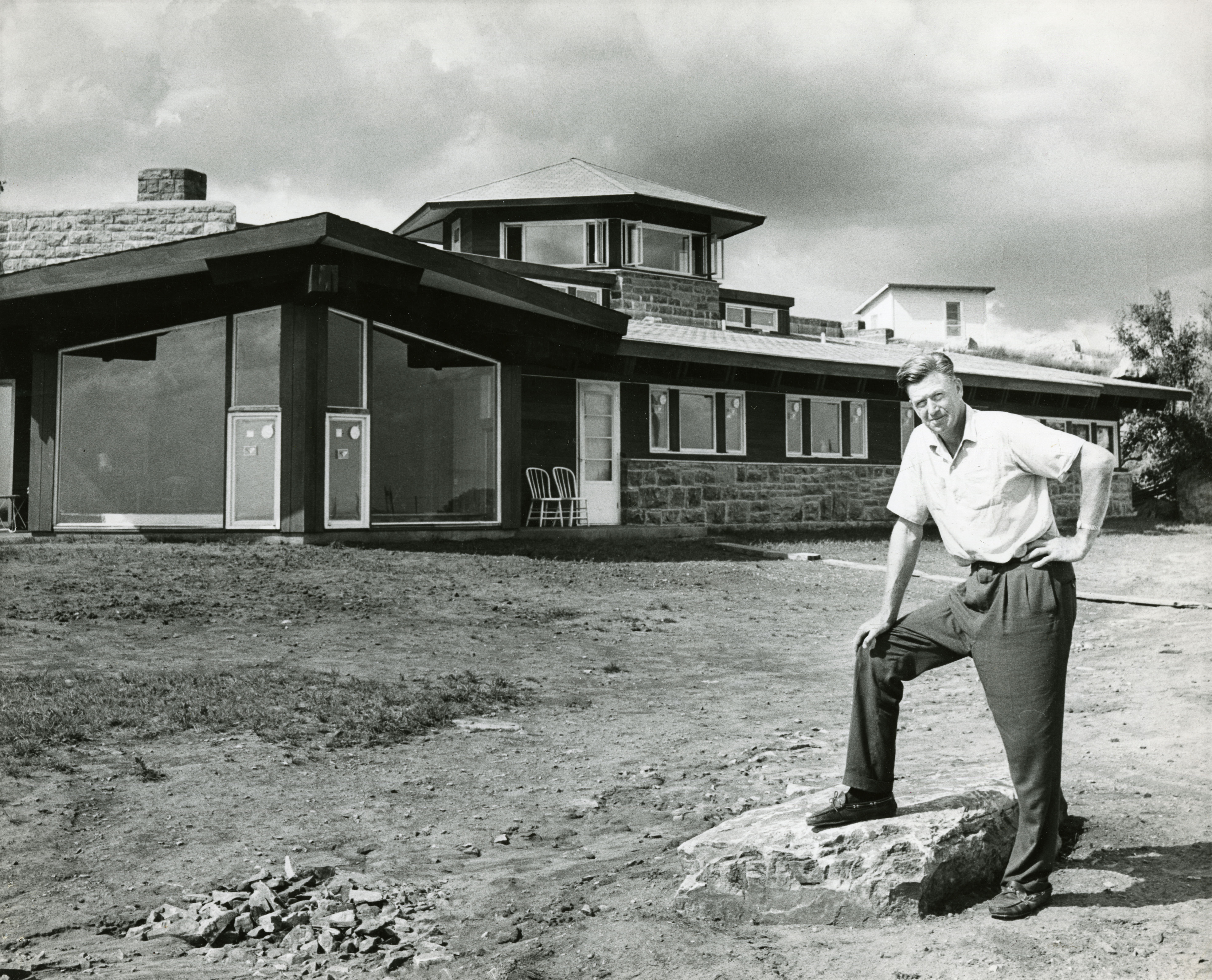 Frederick Manfred in front of the nearly-complete house.